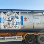 ISO tank containing high-purity n-Heptane, ready for international shipment, with chemical plant in the background.