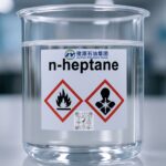 High-purity n-Heptane in sealed laboratory glassware labeled with REACH and CLP hazard pictograms, placed on a compliant chemical safety workstation under bright light.