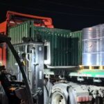 A forklift operator loading drums of n-Hexane at night, preparing them for shipment to the Brazilian market to support soybean oil extraction during the harvest season.