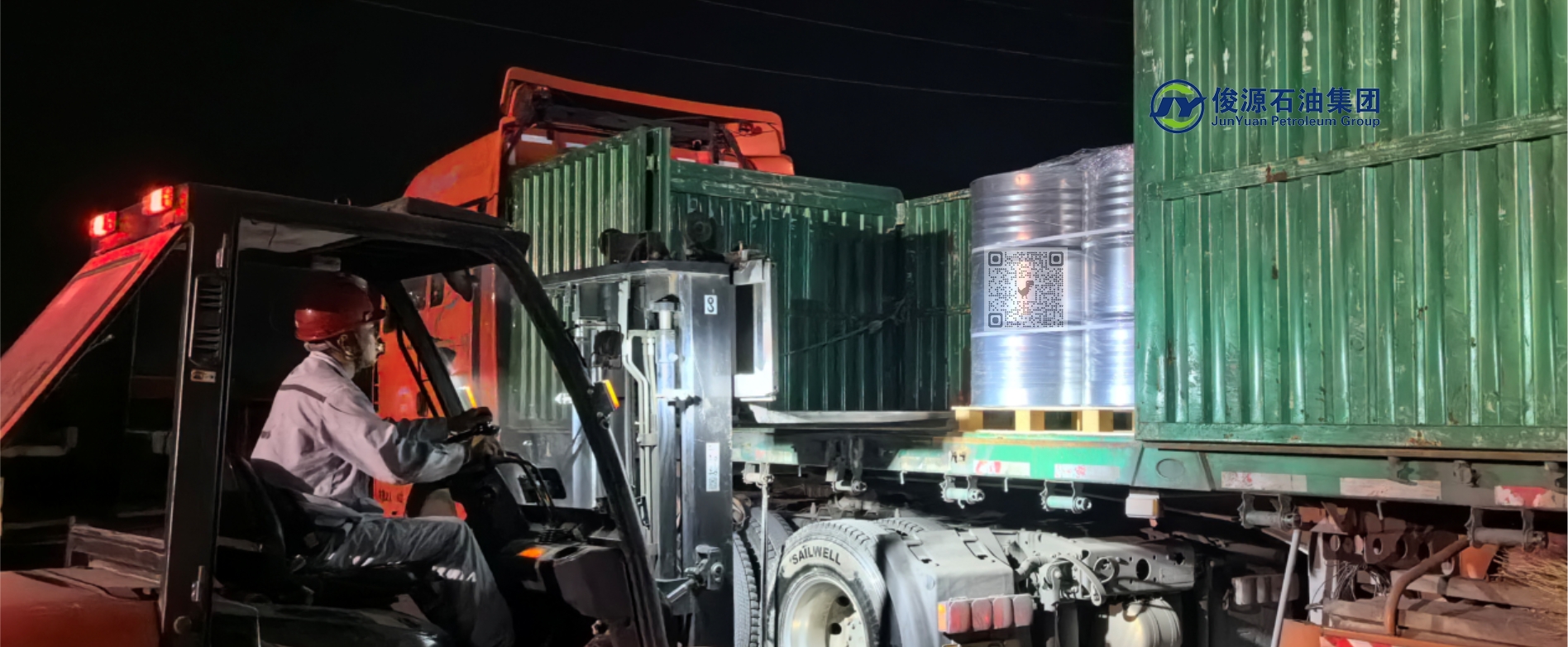A forklift operator loading drums of n-Hexane at night, preparing them for shipment to the Brazilian market to support soybean oil extraction during the harvest season.