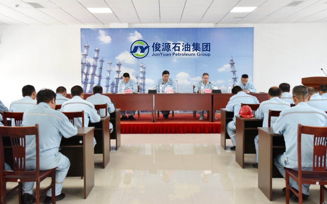 Junyuan Petroleum Group Q3 2026 Safety Committee meeting in progress with employees in uniform seated in the conference room.