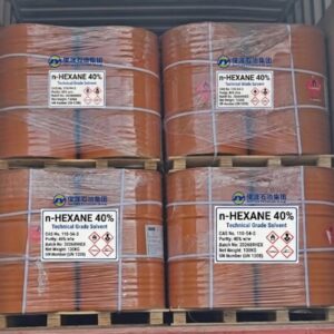Four palletized stacks of orange industrial steel drums containing 40% n-hexane (CAS 110-54-3) with GHS hazard labels, loaded inside a cargo shipping container.